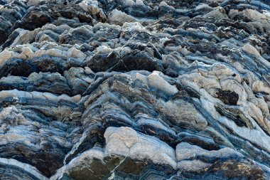 Yunanistan 'ın Girit adasının güney merkez sahilinde çeşitli şekillerde katmanlı kaya oluşum yapısı.