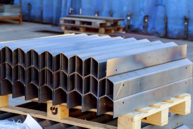 Bükme makinesinde işlem yaptıktan sonra bir yığın metal ürün..