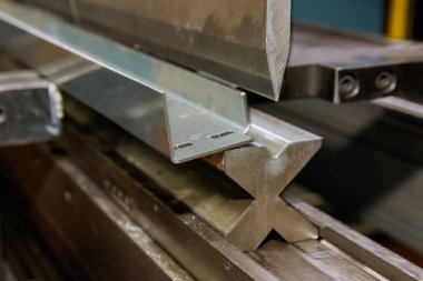 Using hydraulic machine for metal bending, sheet metal will be bent on hydraulic press. Production of metal products.