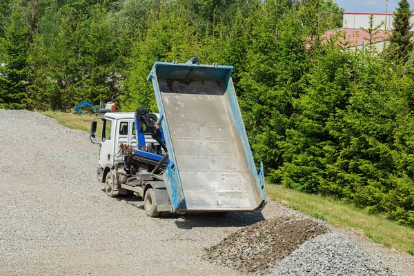 On a construction site, gravel is being dumped by a dump truck.