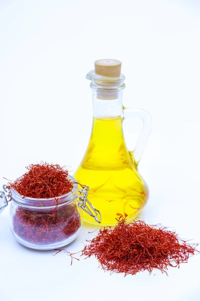 stock image Dried saffron threads in glass bottle and oil extract on white background. A drink made from saffron stamens.