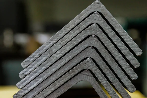 Rolled metal products, L-profile. A stack of angle steel in a factory. Metal profile after cutting with a band saw. L-profil.