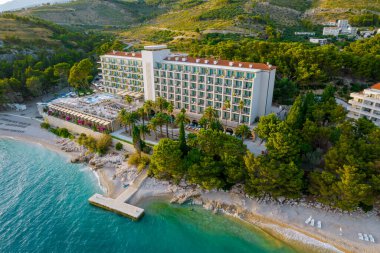 Yukarıdan bak. Deniz kenarında peyzaj yapan bir otel. Kumsal ve iskele. Turistler için güzel bir tatil..