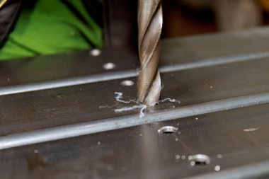 Metal ürünlerin işlenmesi ve delik açılması. Ağır iş ve metal işçiliği konsepti. Metal sütunlarda delik açmak.