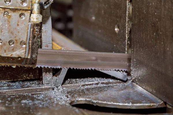Cutting steel profiles and pipes on a band saw in production.