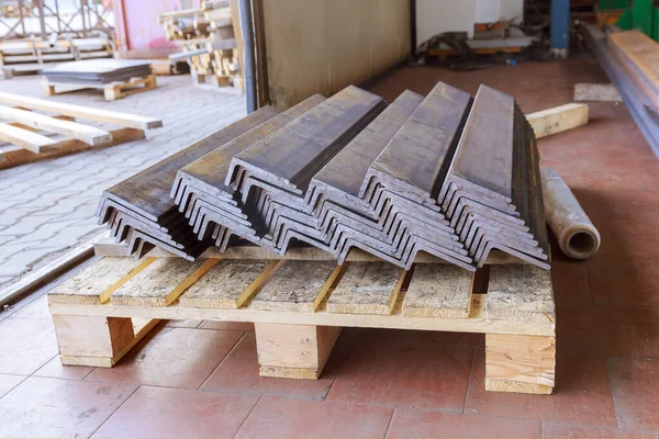 Rolled metal products, L-profile. A stack of angle steel in a factory. Metal profile after cutting with a band saw. L-profil.