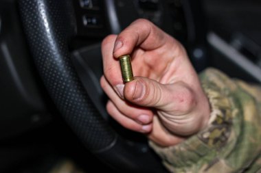 Savaştaki bir askerin kirli eli. Elinde boş bir 8 mm 'lik ya da 9 mm' lik kovan var. Yakın plan..