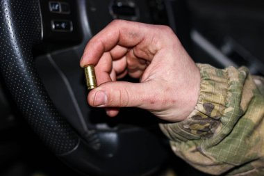 Savaştaki bir askerin kirli eli. Elinde boş bir 8 mm 'lik ya da 9 mm' lik kovan var. Yakın plan..