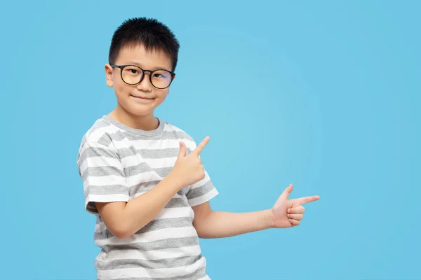 Dzieciak Palcami Wskazującymi Prezentującymi Noszący Okulary Niebieskim Tle — Zdjęcie stockowe