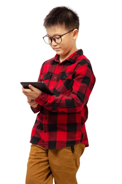 眼鏡をかけタブレットを持ち 白い背景に隔離された赤いシャツを身に着けている子供 — ストック写真