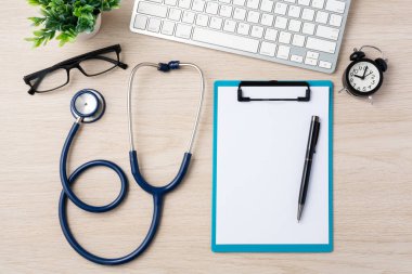 Doktor masası steteskop, dosya ve bilgisayar klavyesi ile ahşap masa, üst görünüm