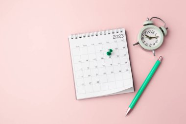 Calendar with pinned date and clock on pastel pink background, planning and scheduling concept, top view with copy space