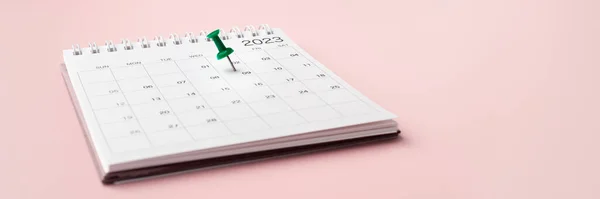 Calendar 2023 with pinned date on pastel pink background, appointment meeting or planning and scheduling concept