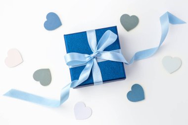Blue gift box with ribbon bow, present with love heart on white background, top view