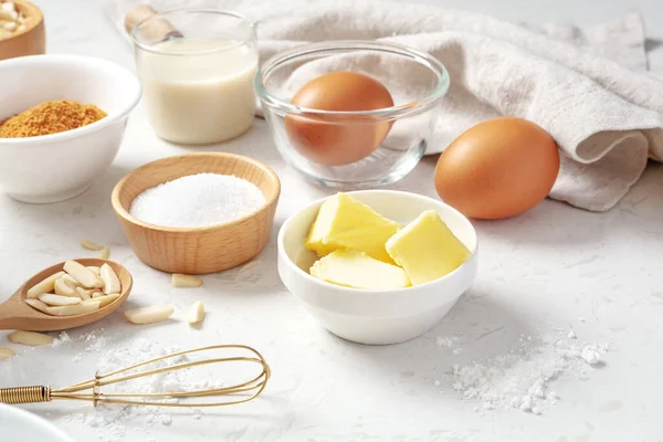 Baking background with pastry or cake ingredients, butter, sugar, flour, eggs and milk on marble table