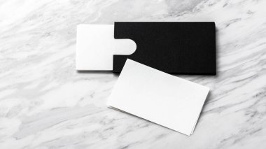 Beyaz mermer arka planda siyah kart sahibi olan bir kartvizit modeli.