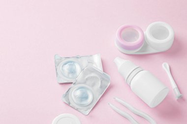 Pembe arka planda konteynır, göz damlası ve aksesuarlarla kontak lensleri, kopyalama alanı