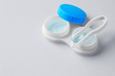 Gri arkaplanda kontak lensler ve cımbız, boşluğu kopyala