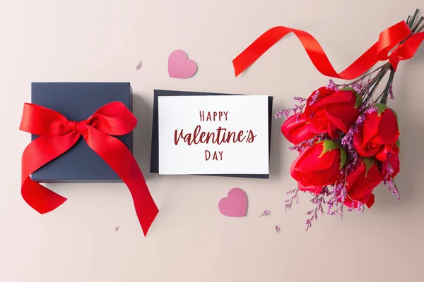 Valentine's day card and black gift box with red bow and rose bouquet on beige background, top view
