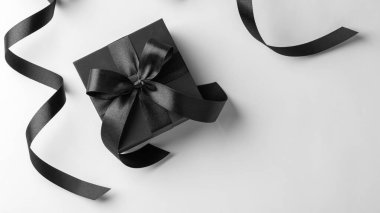 Kara Cuma konsepti, beyaz arka planda siyah kurdeleli hediye kutusu, üst görünüm, boşluk kopyala