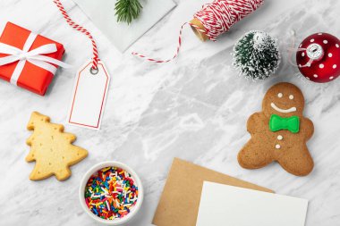 Noel arkaplanı hediye paketi, bayram kartı ve mermer masada zencefilli ekmek, üst manzara, kopyalama alanı
