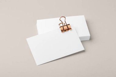 Bakır sarısı klasörü olan boş bir kartvizit. Bej arka planda ataç modeli.