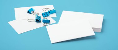 Mavi arkaplanda klasör ataçları olan bir kartvizit modeli