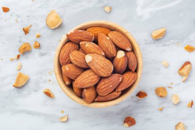 Tahta kasede badem, mermer masa zemininde kırık badem, üst manzara.