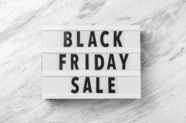 Kara Cuma kelimesi aydınlatma kutusunda mermer masa arka planında, üst görünümde.