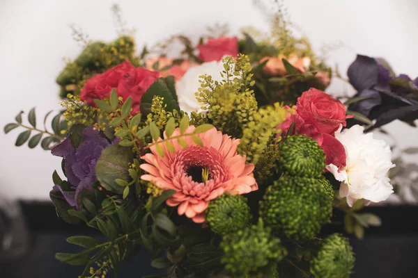 Beautiful flower arrangement close-up, a bouquet of mixed flowers from carnations in gerberas in a flower shop