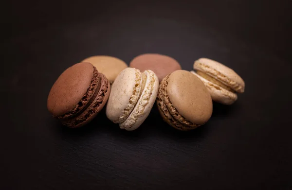 Macarons Aux Couleurs Beige Marron Crème Sur Fond Ardoise Noire — Photo
