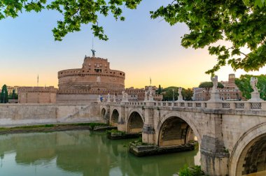 Roma, İtalya 'daki Castel Sant' Angelo 'nun baş döndürücü gündoğumu manzarası, Tiber Nehri' ni kaplayan tarihi Ponte Sant 'Angelo köprüsü..