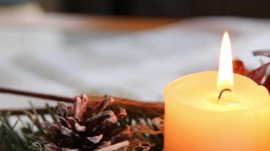 Noel çelengi üzerinde yanan dört mum, Noel arifesinde ve Noel tatillerinde, geleneksel Hıristiyan sembolü olarak süslenmiş bir Noel ağacının önünde romantik bir ruh haliyle parlıyor.