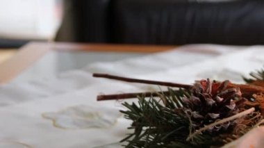 Noel çelengi üzerinde yanan dört mum, Noel arifesinde ve Noel tatillerinde, geleneksel Hıristiyan sembolü olarak süslenmiş bir Noel ağacının önünde romantik bir ruh haliyle parlıyor.