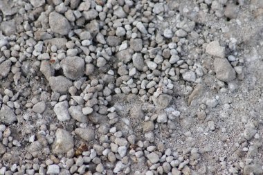 Gri ham kayalar ve kaba taşlar doğal taşların arka planında ezilmiş ve kabataslak malzemeler yapı malzemesi ya da gri renklerde beton karışımı doğal taşların arka planı olarak kayalık temeller oluşturur.