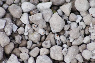 Gri ham kayalar ve kaba taşlar doğal taşların arka planında ezilmiş ve kabataslak malzemeler yapı malzemesi ya da gri renklerde beton karışımı doğal taşların arka planı olarak kayalık temeller oluşturur.