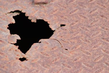 Paslı metal plaka paslanmış eski paslanmış diamant plaka üzerinde delikler gösteriyor ki grunge çelik ve yıpranmış metal pas yağmurlu havadan zarar görmüş buhar punk senaryoları ve hasarlı yüzey çelik plaka