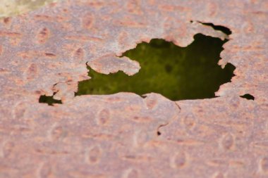 Paslı metal plaka paslanmış eski paslanmış diamant plaka üzerinde delikler gösteriyor ki grunge çelik ve yıpranmış metal pas yağmurlu havadan zarar görmüş buhar punk senaryoları ve hasarlı yüzey çelik plaka