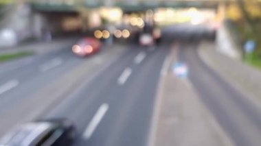 Bulanık şehir trafiği arka planında şehir trafiğinde hareket halindeki otomobiller şehir sokaklarında ve şehir taşımacılığı sektöründe kamyonlar ve otomobiller trafiğin yoğun olduğu saatlerde kasabalarda geziyor.