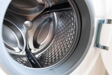 İçi paslanmaz çelik varillerle dolu çamaşır makinesine bakın. Temizlik için ev aletleri, kuru temizlemeci ve çamaşır makinesinin ön yükleyicisini gösteriyor.