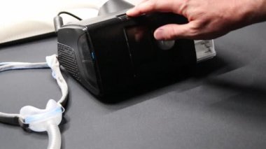 Cpap filtresi veya sağlık kontrolü için nemlendirici gibi terapi ekipmanlarını kontrol eden Cpap makineli erkek Avrupalı ve uyku apnesi maskeli yenilikçi sağlıklı uyku solunum sistemi için gece hazırlayıcı