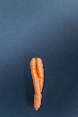 Siyah arka planda çarpık havuçlar. Organik çiftçiden birbirine aşık çiftlerin sembolü olarak. Bükülmüş havuç, idrarını tutamama ve vajinal mantar ya da evde yetişen sağlıklı beslenme.