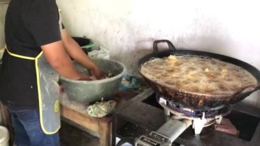 Tavuk satıcıları tavuğu kızgın yağ tenceresinde kızartırlar.