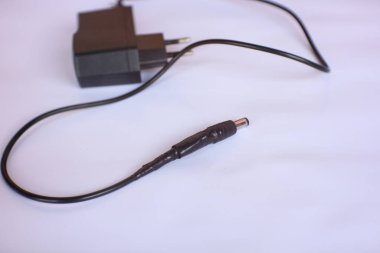 İzole edilmiş beyaz arkaplanda siyah renkli şarj adaptörü.