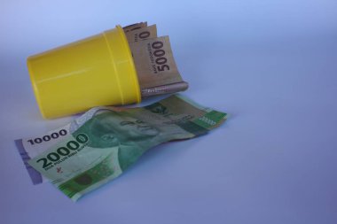 Endonezya rupia banknotları. Finans, yatırım, ekonomi, iş ve başarı kavramı. Sarı bardaktaki para. Paranı kendine sakla. Para 5000 10000 20.000 Rupiah
