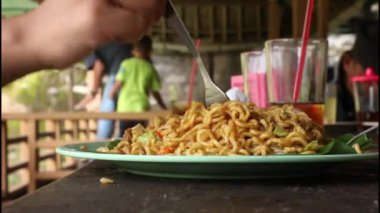 Kızarmış erişte ve sebze ye ve kaşık kullan.