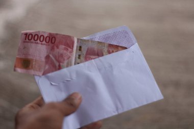 Beyaz bir zarfın içinde Endonezya rupia parasının bulanık arka planı.