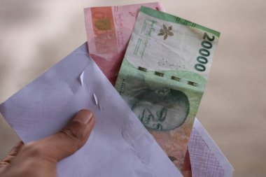 Beyaz bir zarfın içinde Endonezya rupia parasının bulanık arka planı.