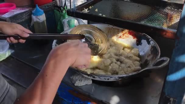 インドネシアのストリートフードベンダーがお客様にサービスを提供しています 通りのお客様に バタゴール と呼ばれるお料理を用意している男性 — ストック動画