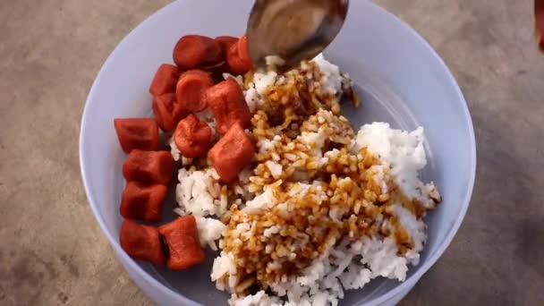 伝統的な方法は 甘い醤油で振りかけた揚げソーセージと米を食べることです — ストック動画